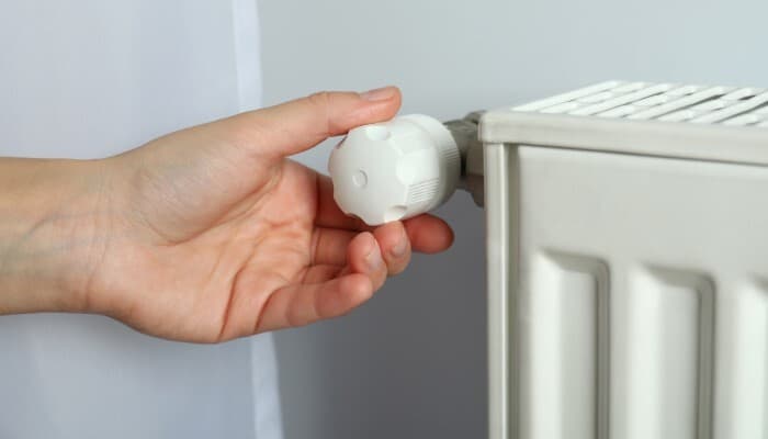 Man turning radiator on