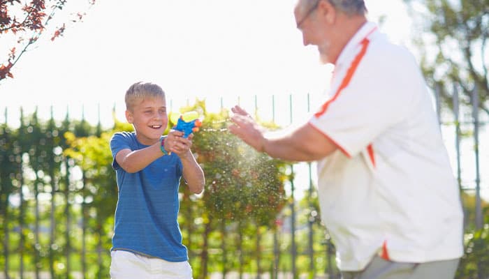 child using a water blaster outdoors